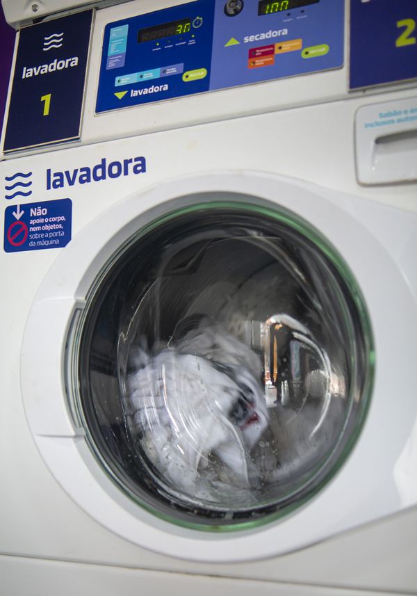 Lavadora industrial da Lavô em funcionamento, com as roupas girando dentro do tambor
